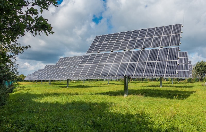 Image of a Solar Farm with Solar Panel arranged in a row next to each other in an open field.