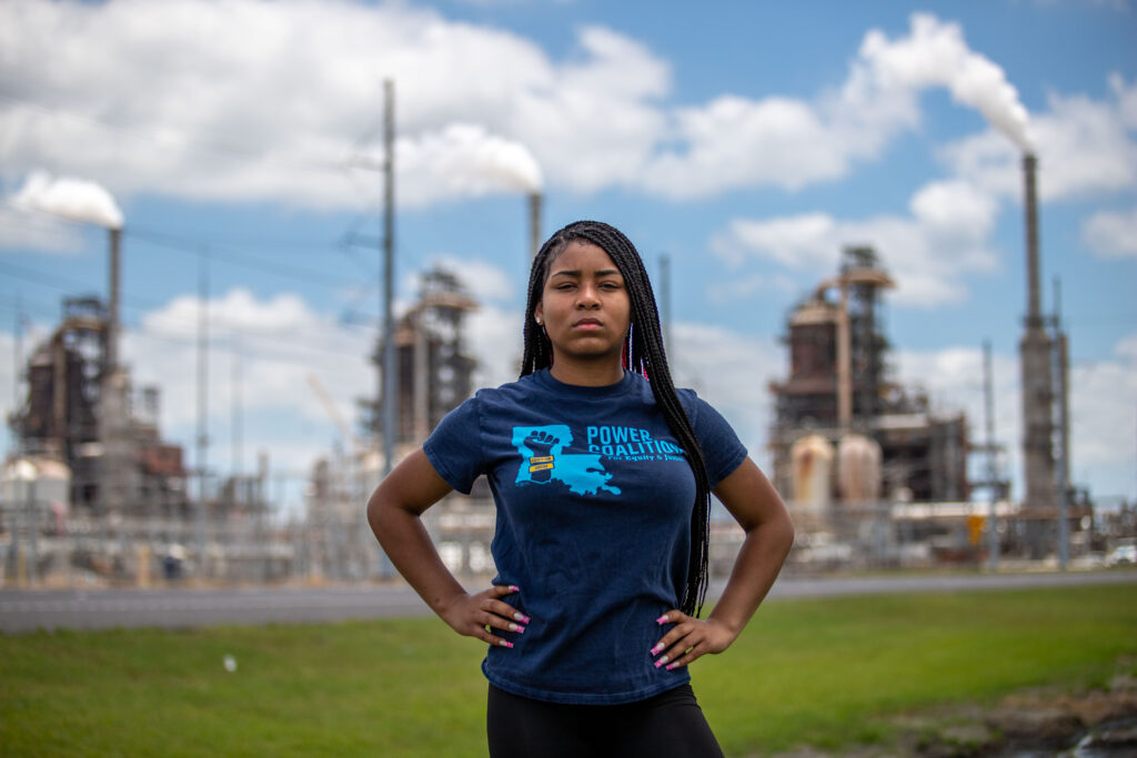Kami, a 15-year-old from Sulphur, Louisiana, stands in front of a liquefied natural gas plant.